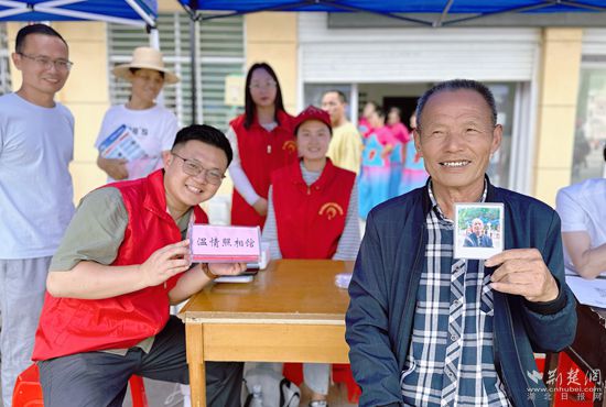 “溫情照相館”攤位上，前來照相的老人與志愿者開心地合影留念_副本.jpg